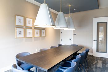 A conference room with a long table and blue chairs at The Crest at South Point Apartments, Georgia, 30253